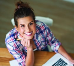 woman smiling at desk with laptop