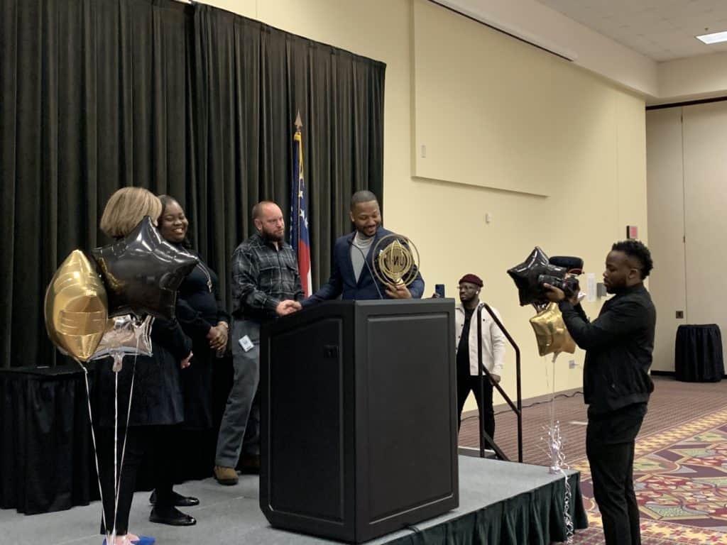 At the conclusion of his speech, OFTC's President, Erica Harden, VP of Student Affairs, Dr. Saketha Adams, and OFTC Machine Tool Instructor, Jeff Frady, presented Norman Gyamfi with a gift made by OFTC's Machine Tool Program - a display of his company's logo - 'Undivided.'